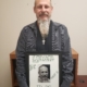 Brent, a member of the guiding light recovery program, holding a picture with his photo and commitment to the program