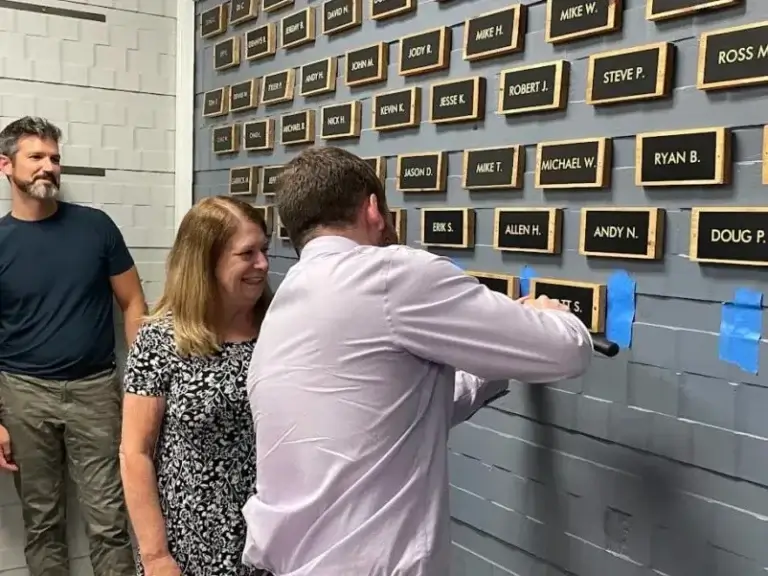 Matt S nailing his recovery plaque to the wall at Guiding Light